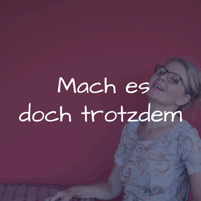 Lachende Frau vor einer roten Wand – frech, lebendig und echt. Ein Bild dafür, wie wir trotz Angst handeln und mit Leichtigkeit mutige Schritte gehen können.