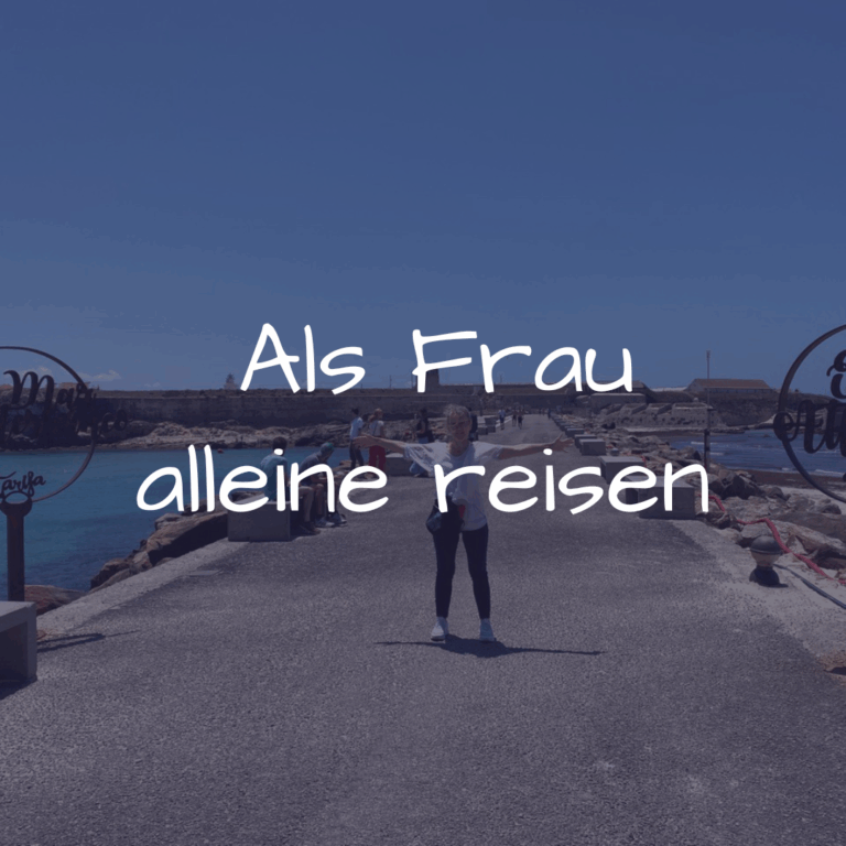 Alleine reisen als Frau mit Camper – Carmen steht mit ausgebreiteten Armen zwischen Mittelmeer und Atlantik in Tarifa, bereit für ihr Abenteuer.